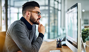 man looking at a computer with data on it 