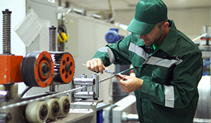 Man in a green utility jacket fixing steel rod