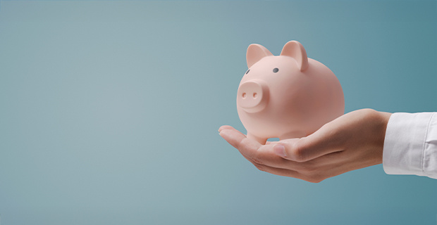 A hand extended outward holding a piggy bank